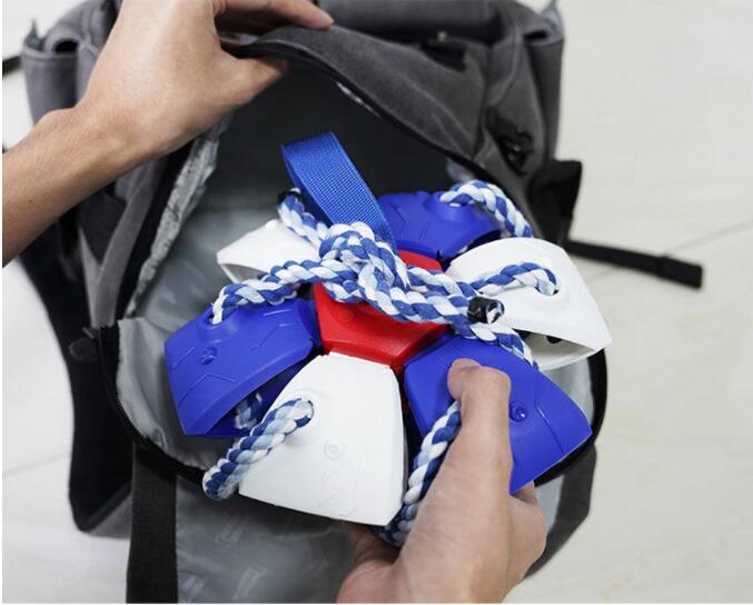 Person holding a colorful object with blue, red, and white elements against a backpack background.
